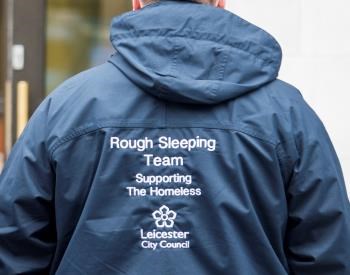 Male in coat with writing on the back it reads 'Rough Sleeping Team, supporting the homeless, Leicester City Council'