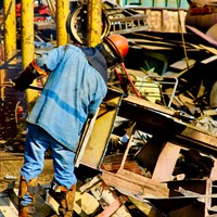 Man in PPE handling scrap metal