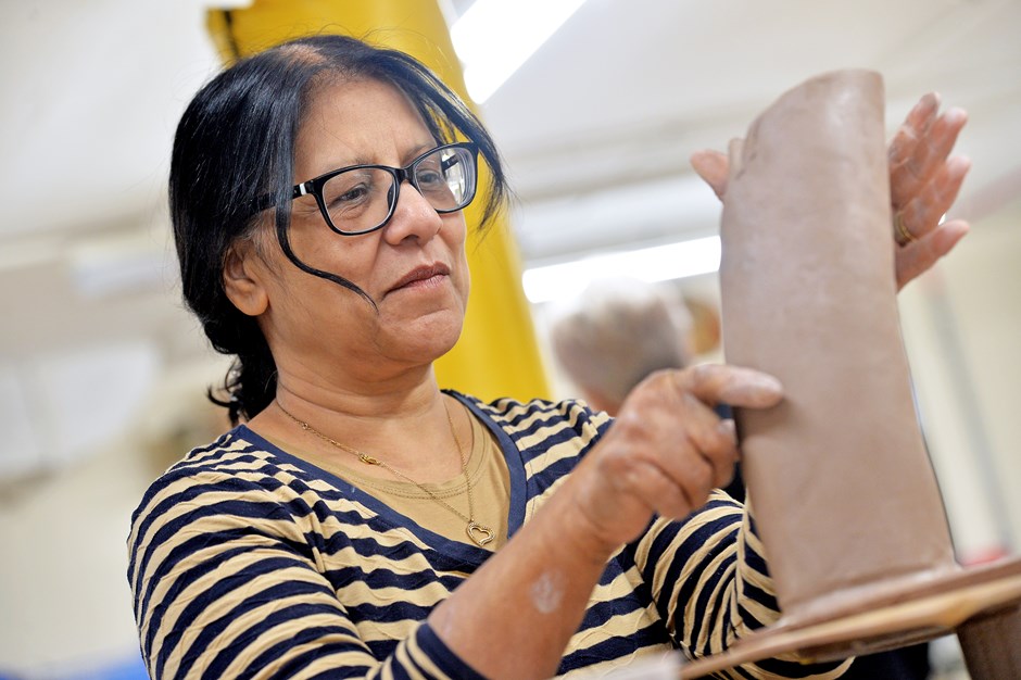 Woman concentrating on making a ceramic sculpture