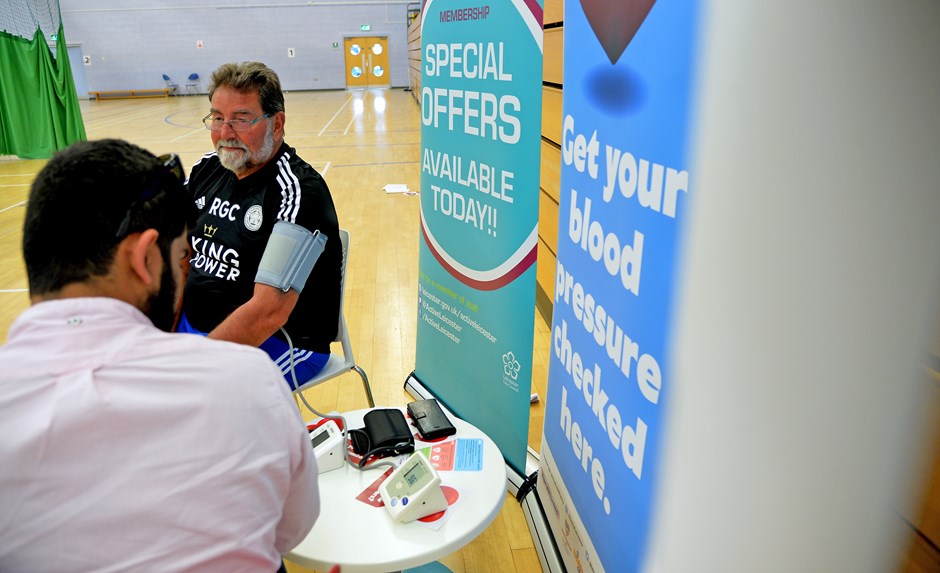 Man having blood pressure checked in a sports hall