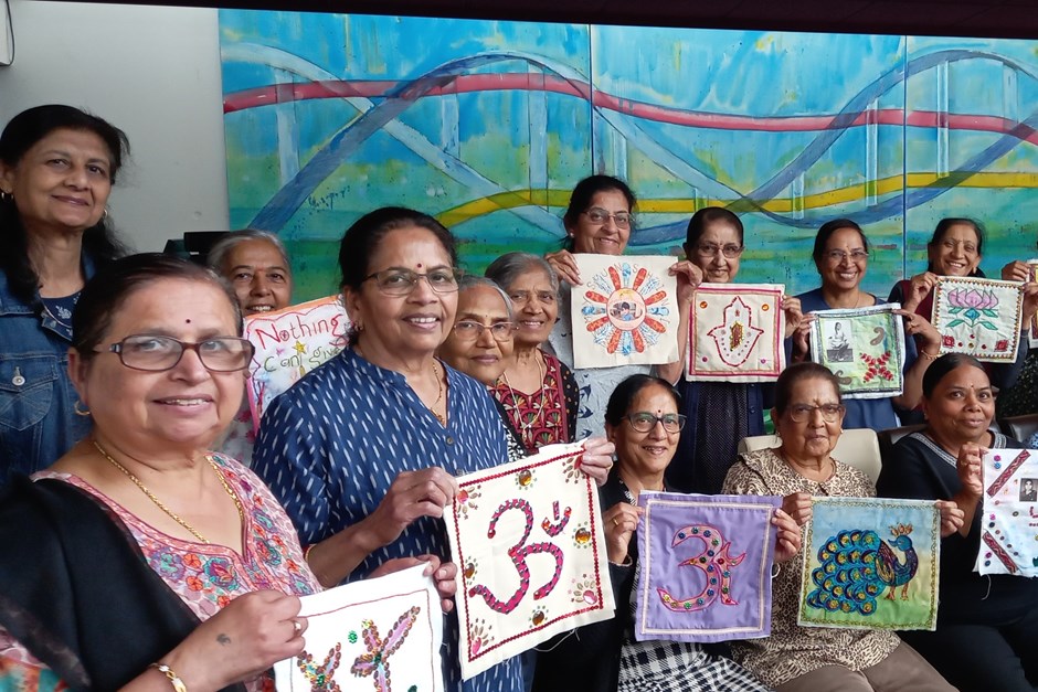 Group of women displaying embroidery